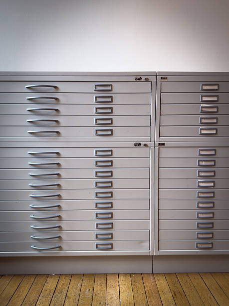A close view shows a modern filing cabinet filled with gray closed drawers.