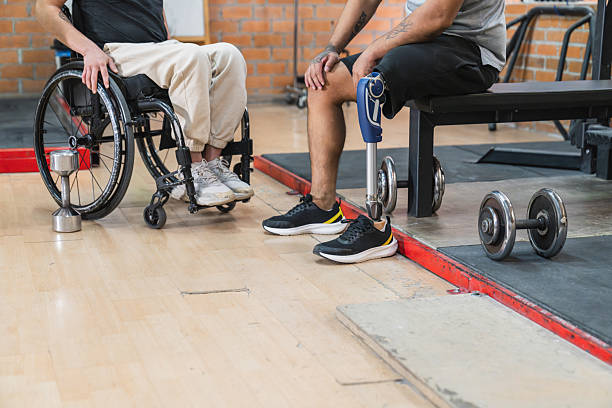 Detail of the legs of an elderly woman with a walker who is being cared for by nursing staff.