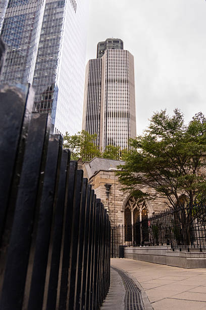 Beautiful gothic style church with a tall tower lingering right behind it, co-existing as one in London, United Kingdom
