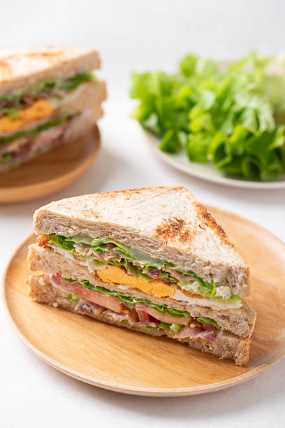 Whole wheat bread sandwich with bacon, lettuce, tomato and fried egg