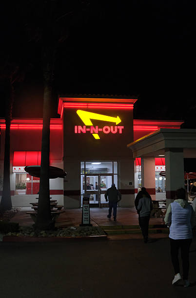 Santa Nella, California, USA - February 14, 2026:View at the In-n-out Burger restaurant from the parking lot, at night. Patrons sitting and dinning inside. In-N-Out Burger, Inc. is a regional chain of fast food restaurants with locations primarily in the American Southwest and Pacific coast.