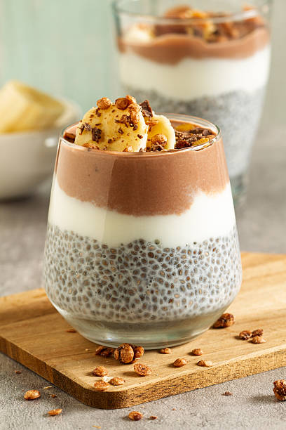 Layered chia pudding in glass with creamy dessert topping, healthy breakfast parfait