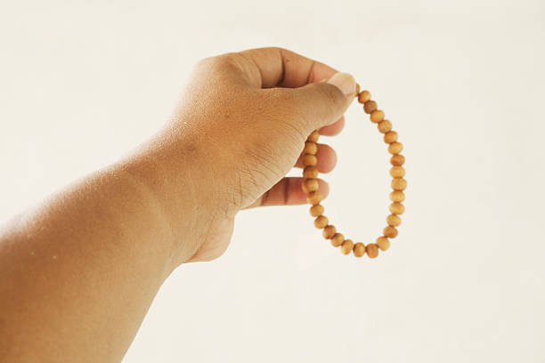 Hand Holding Wooden Prayer Beads