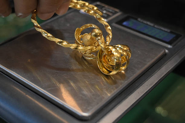 A close-up view of a native gold mineral specimen showcasing its intricate, branching structure with a bright, metallic luster against a dark background