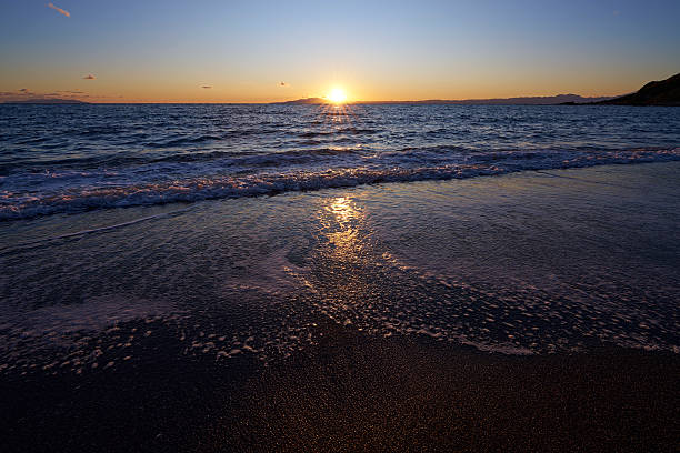 The wet sand acts as a mirror, shattering and reflecting the sunset into countless fragments. A beauty akin to scattered jewels gorgeously colors the boundary between sea and land.