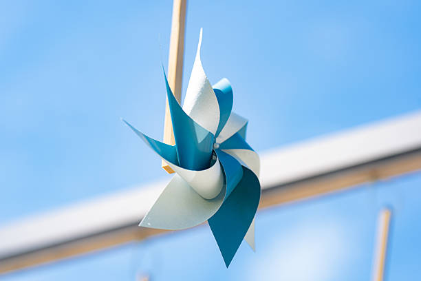 A single blue pinwheel spinning under a clear blue sky.
