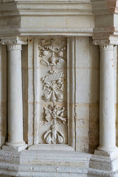 Elaborate Gothic stone carving features complex figurative composition at Fontevraud Abbey in the Loire Valley, France. The sculptural relief demonstrates sophisticated medieval craftsmanship with multiple figures in narrative arrangement, characteristic flowing drapery, and architectural framing elements. The pale tuffeau limestone allows intricate detail work, where skilled carvers created dynamic compositions within relatively shallow relief. Such figurative programs communicated religious narratives, theological concepts, and hagiographic stories to monastic communities and visitors, fulfilling educational functions beyond their decorative roles. The quality and complexity of the carving reflects Fontevraud's exceptional status as royal abbey with substantial resources devoted to artistic programs demonstrating both religious devotion and aristocratic patronage throughout its medieval history.