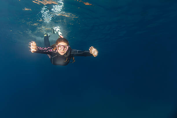 Girl swimming in crystal clear water with dress on