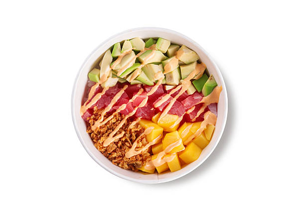 Top view of fresh tuna poke bowl with mango avocado crispy onions rice and spicy sauce isolated on white background