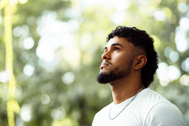 istock Young man looking up in nature with hope 2262164182