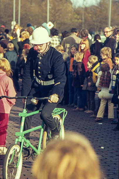 Participant dressed as a comic police officer, possibly portraying “Agent Snuf” from the Dutch television series Pipo de Clown, during the annual Sinterklaas arrival parade at Museumplein in front of the Rijksmuseum in Amsterdam, November 1971. The character Agent Snuf was portrayed in the series by Cor Witschge. The parade featured several figures from popular children’s programs. Scanned from original color slide. Circa 1971, Museumplein, Amsterdam, The Netherlands.