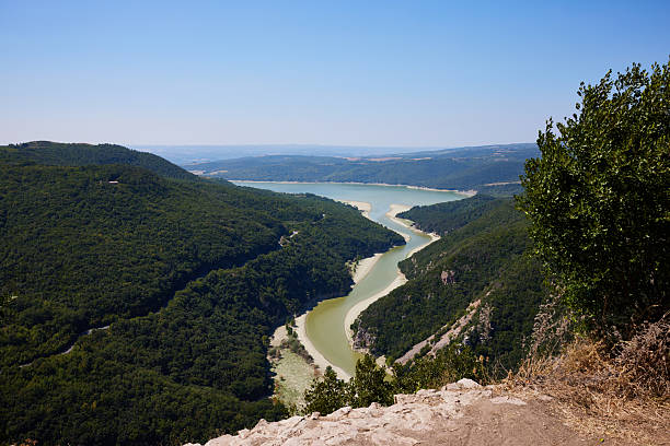 Picturesque idyllic shot of Tiber River passing through lush mountains against clear blue sky during sunny day at Titignano, Umbria, Italy
