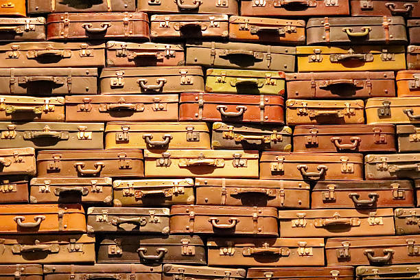 many vintage leather suitcases stacked or clustered together, creating an intriguing pattern and texture. vintage leather suitcase collection background texture.