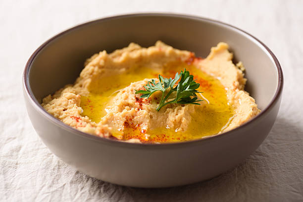 Healthy vegan snack, chickpea hummus dip topped with paprika and fresh parsley