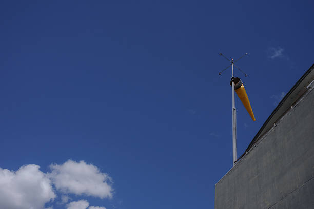 Part of the Quiet Urban Textures series, this image explores the subtle character of city surfaces through material, detail and atmosphere. Minimal urban rooftop detail and a yellow windsock under a deep blue sky with ample copy space.
