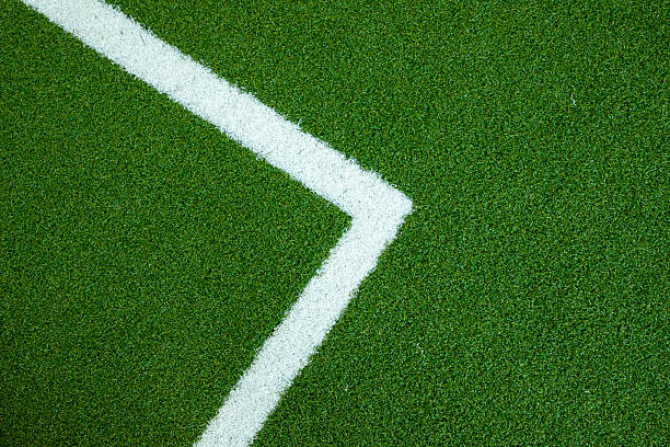 A white line on a green field. The white line is in the shape of an arrow