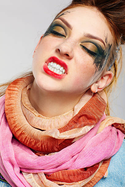 Smiling woman with creative hairstyle and makeup on black background