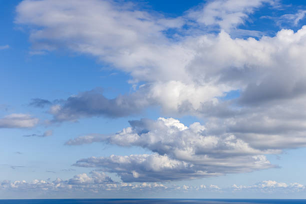 Expansive cloud filled sky over distant ocean horizon for visual projects, soft natural light and airy cloud forms provide versatile backdrop for compositing templates and creative scenes