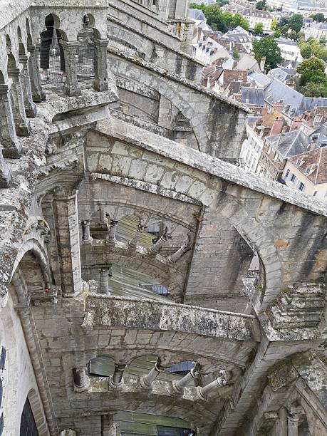 A view through the intricate stone arches and galleries of Chartres Cathedral looking down toward the rooftops of the historic district in Chartres, Eure-et-Loir, France.