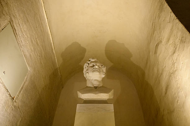 Paris, France - May 11, 2022: A marble bust is displayed in a small alcove with textured walls and artificial lighting inside the Arc de Triomphe monument.