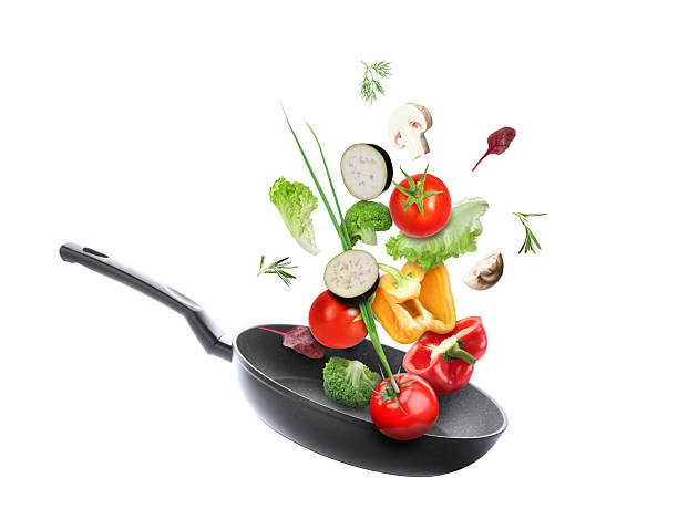 istock Frying pan and different vegetables in air on white background 2262267811