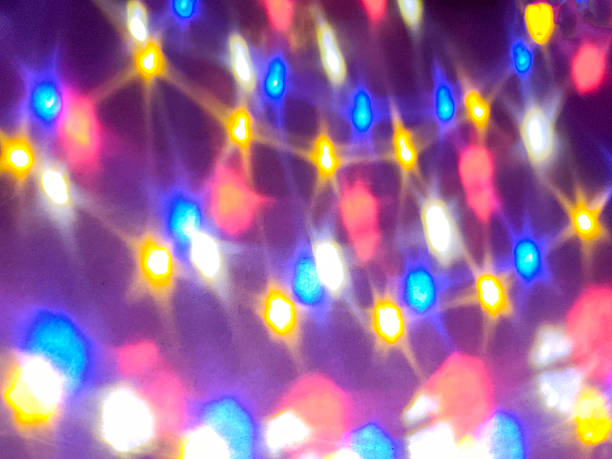 Colorful blurred LED lights creating abstract bokeh background. Festive glowing illumination with blue, yellow and pink tones, holiday decoration concept.
