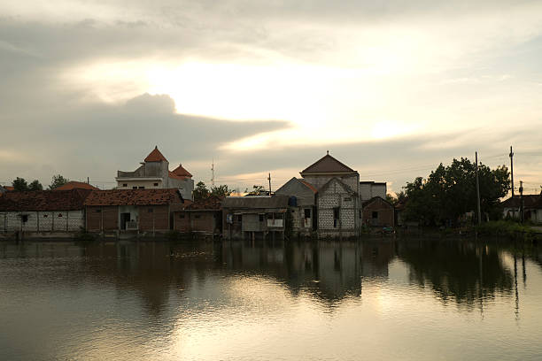 Peaceful Evening Landscape with Water Pond Between Houses