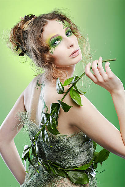 portrait of beautiful female with fairy theme bodyart posing on green