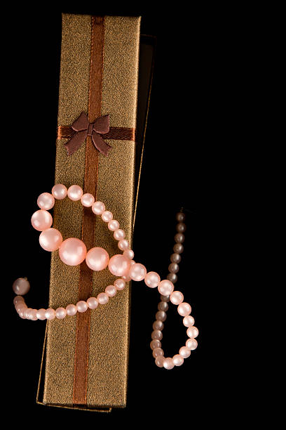 Elegant gift box with pearls and copy space on black background