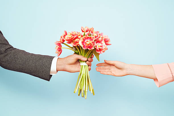 Couple in love holding a bouquet of tulips on a blue background. The concept of Valentine's Day, March 8