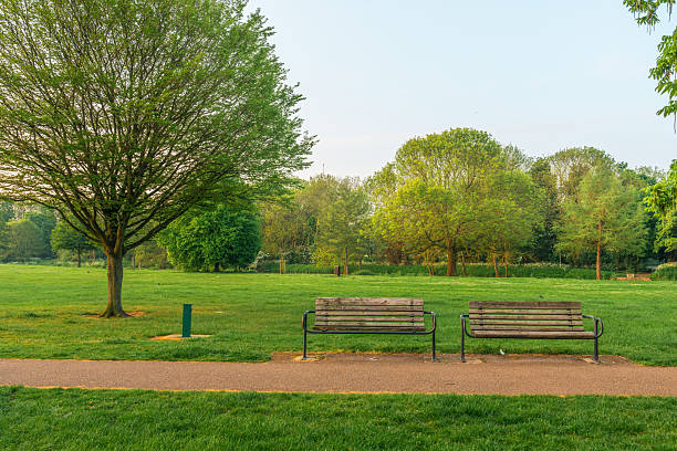 Two empty benches inviting visitors to relax in bedford park, england