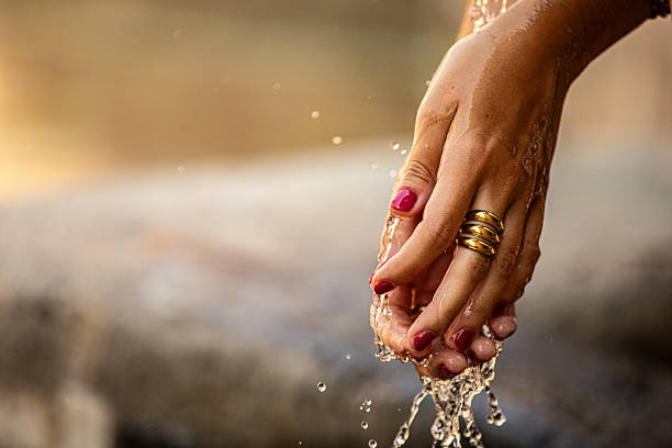 person collecting water with hands