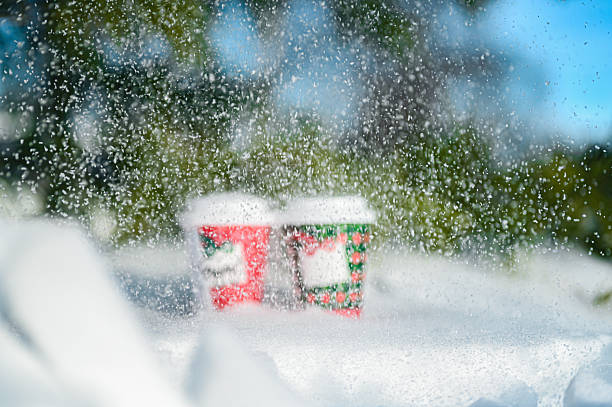 Festive coffee mugs standing in fresh white winter snow
