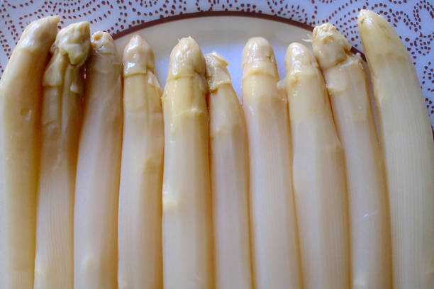 Fresh green asparagus arranged on a rustic surface, ready to be cooked. The image highlights seasonal produce, natural texture, and healthy ingredients. Ideal for themes such as vegetarian cuisine, Mediterranean diet, and spring vegetables.