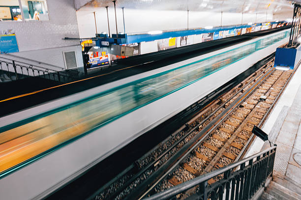 Paris, France - Long exposure view of a Parisian metro train speeding through an underground station creating dynamic motion blur along the railway tracks, with tiled walls, platform architecture, and urban public transport atmosphere representing fast paced city commuting and European metropolitan mobility