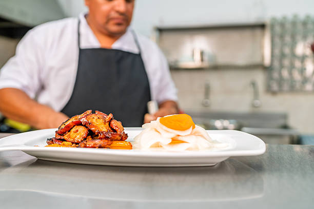 Professional chef preparing and plating a gourmet chinese-peruvian fusion dish, showcasing culinary excellence in a chifa restaurant kitchen