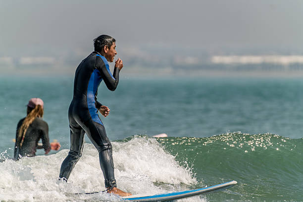 The Pacific Rim National Park in British Columbia on March 02, 2024: Young male surfer returning after a session at Pacific Rim National Park on Vancouver Island at sunset, British Columbia