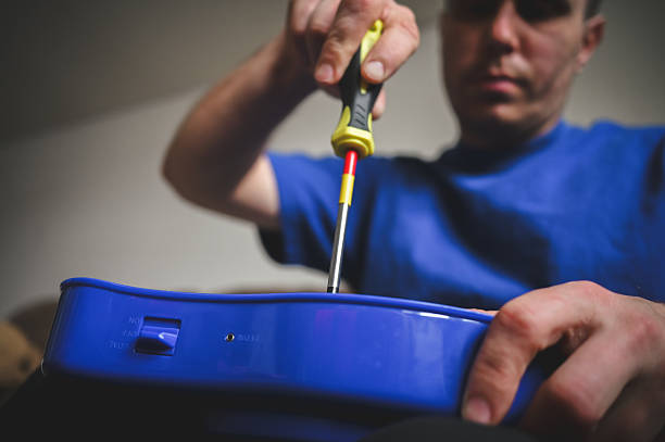 Close up view of hands screwing open a blue electronic device