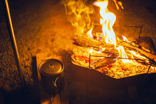 closeup touristic cauldron on a fire in the forest, summer outdoor camping scene
