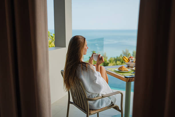 Woman enjoying breakfast on a luxury hotel balcony