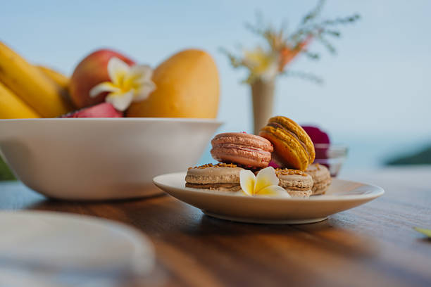 Macarons and tropical fruit on table