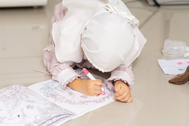 A daughter is drawing a book on the floor