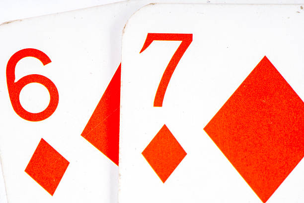 Close-up of playing cards showing red diamonds six and seven, arranged on a clean white surface, emphasizing the classic design and vibrant colors of card games