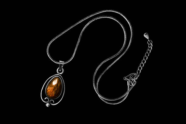 Elegant vintage amber pendant silver necklace isolated on black background
