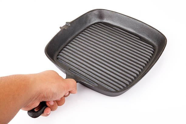 hand hold empty grill iron pan isolated on white background