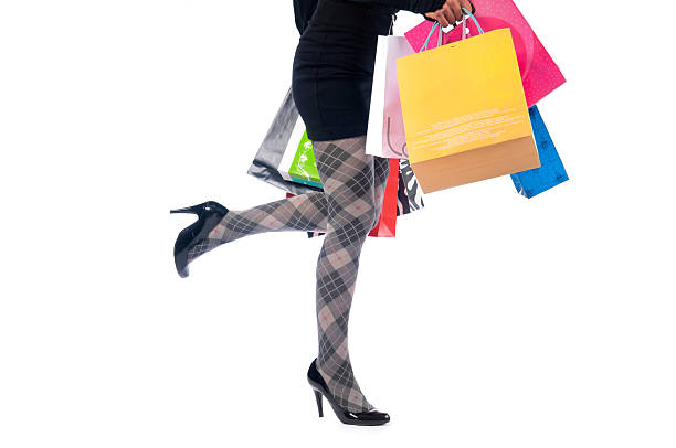 Closeup of slender slim female legs dressed in high heel. Young woman is trying on, choosing comfortable fashionable shoes to buy in store, boutique at center, mall. Black friday. Shopping and sale.