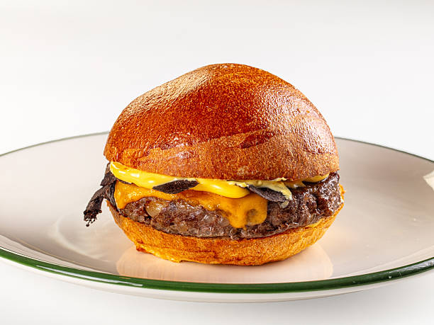 Gourmet truffle cheeseburger with a brioche bun on a white plate