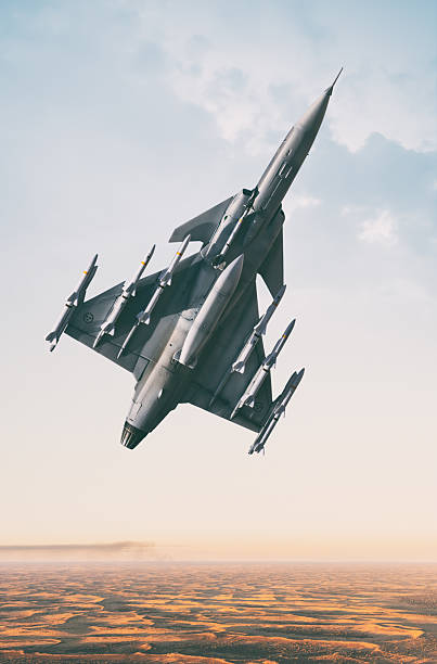 A JAS-39D Gripen Fighter Jet streaks through the sky, high above the sand dunes of a desert. Scale model photography