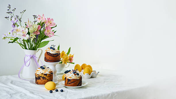 Traditional Easter cakes on festive table decorated with fresh flowers and colorful painted Easter eggs. Kulich is kind of Easter bread that is traditional in the Orthodox Christian faith