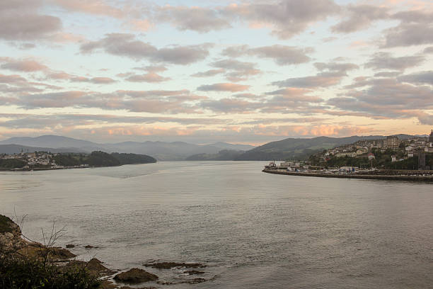 Looking towards Ribadeo from the bridge, showing the water reflections and the town's coastline at twilight.